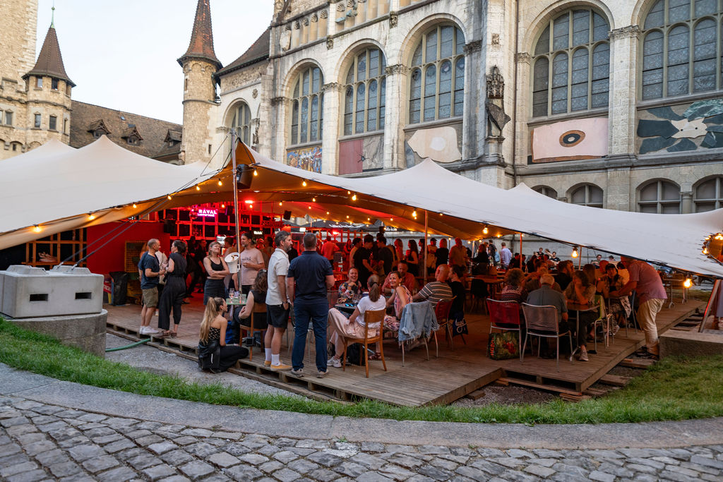 Gäste beim Apero und Dinner unter dem Schermen des Hofkino Zürich – gesellige Abendstimmung im Innenhof des Landesmuseums